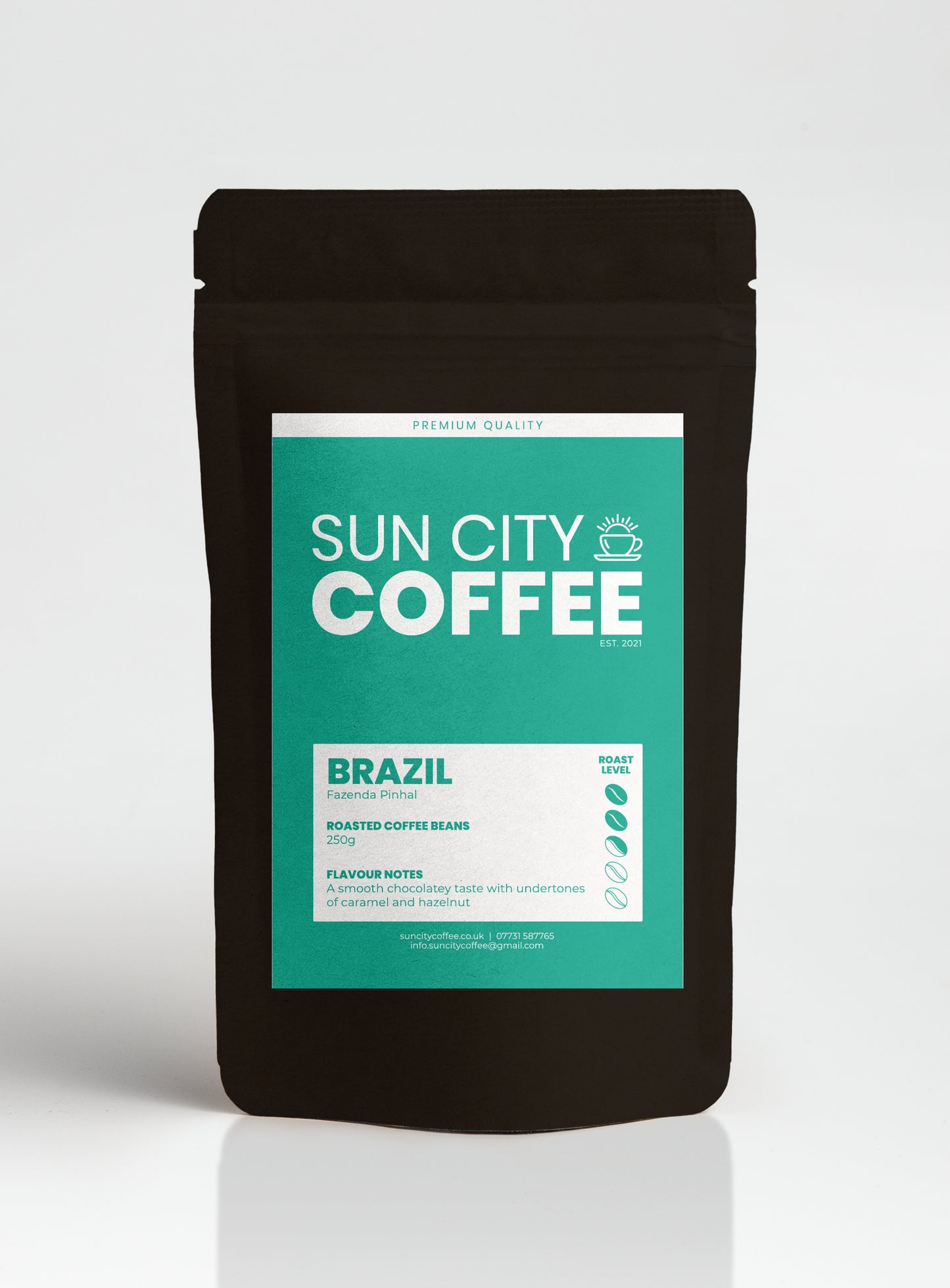 A packaged bag of Sun City Coffee Brazil single origin coffee, which is a light medium roast coffee with blue/ green label