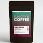 A packaged bag of Sun City Coffee's Day Break Blend single origin beans from Brazil & El Salvador in a black bag with colouful label